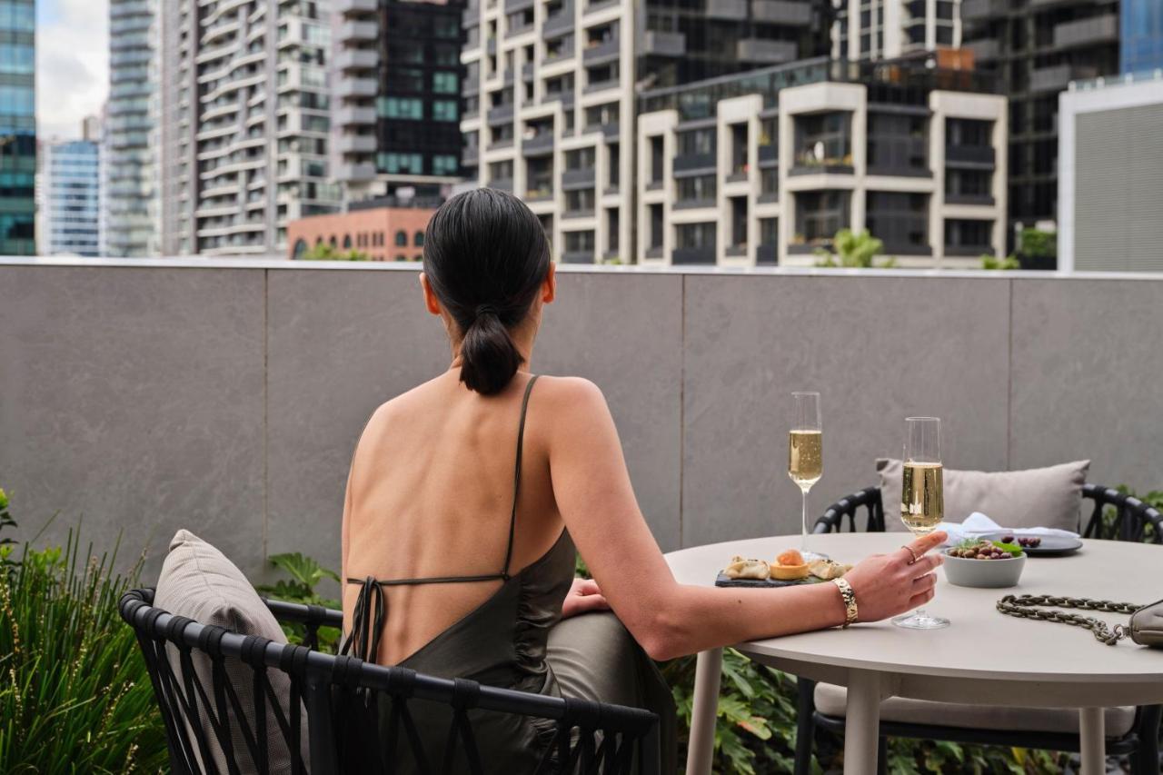 Melbourne Marriott Hotel Docklands Exterior foto A woman sitting on a balcony
